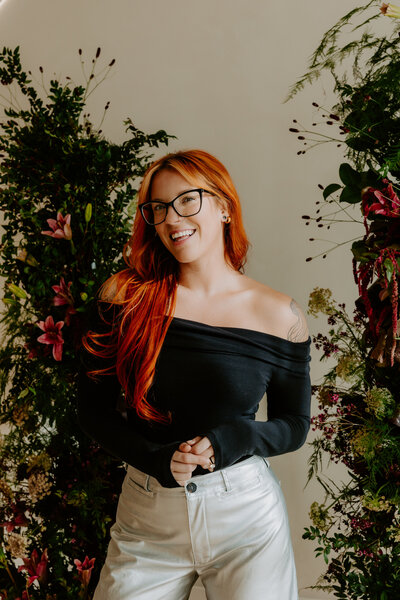 woman posing in a black blazer smiling