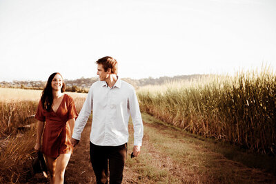 Engagement couple holding hands while walking