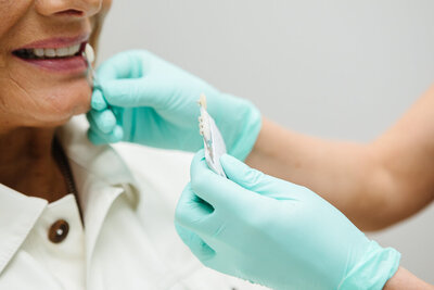 Prosthodontist selecting the best veneer colour for a patient’s smile at Peak Prosthodontics in Lethbridge, Alberta.