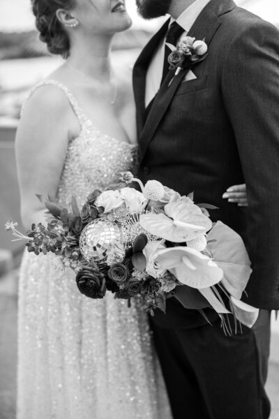 Bride holds bouquet with disco ball and anthuriums at District Winery