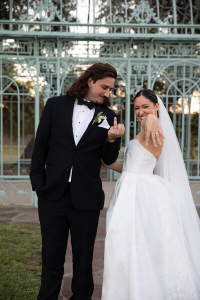A bride and groom, captured by an Austin-based wedding photographer, posing for a picture in front of a gazebo.