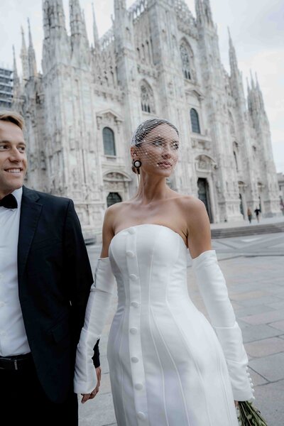 couple embracing during intimate elopement in auckland with mountains in the background