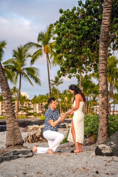 Man down on one knee proposing to his partner on the beach at the Fairmont Orchid in Hawaii, photographed by Hawaii Adventure Portraits, a Big Island proposal photographer