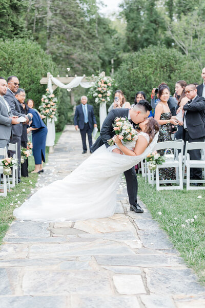 Bride and groom kissing in the aisle