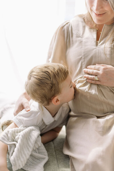 Richmond maternity photographer | Filmclose-up photo of a little boy kissing his pregnant mother's belly in a bright and airy studio by Jacqueline Aimee Portraits