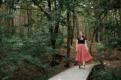 a girl walking amongst trees