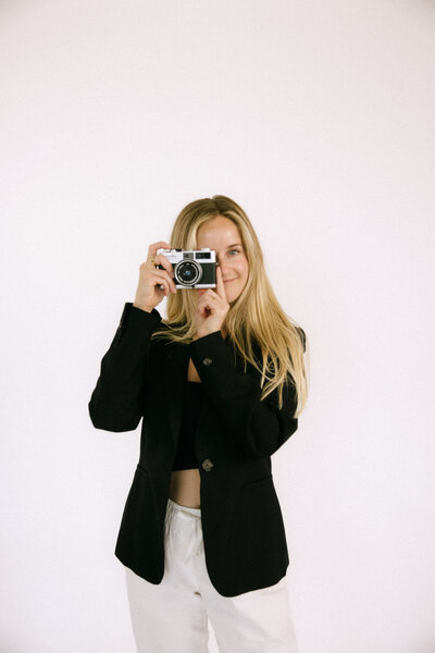 a California brand and couples photographer holding up a camera in her portrait