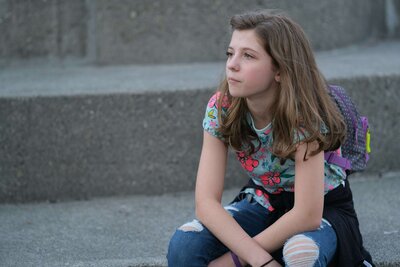 preteen girl with brunette hair and bright shirt