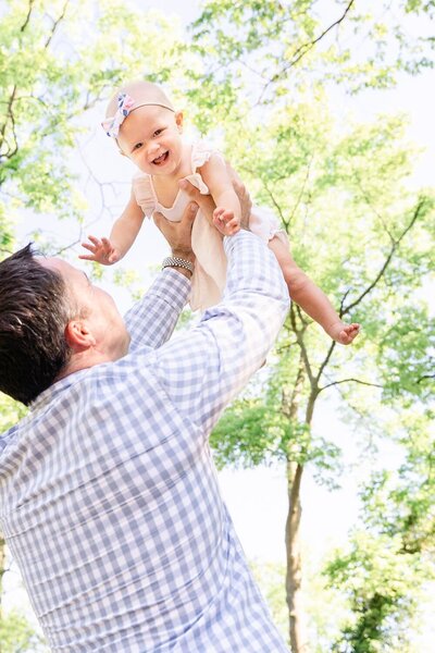 dad playing with baby girl during their family photos in Ashburn, VA taken by a Loudoun County, Virginia family photographer