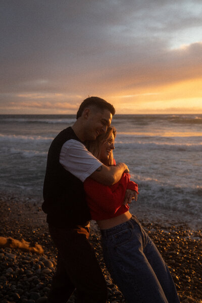 Couple embracing on San Diego beach at sunset
