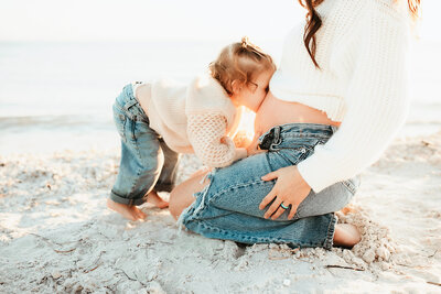 Toddler kissing moms belling in the Tampa Florida Sun.