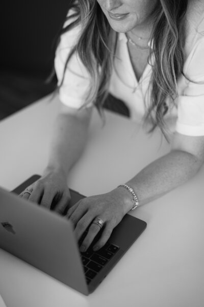Woman sitting in a chair typing on the laptop