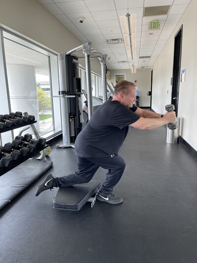 Male client performs a Skater Squat in a gym setting