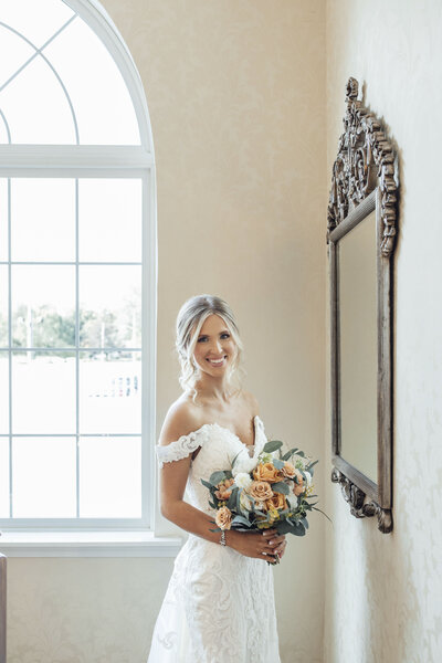 The English Manor | Bride with bouquet looking in mirror before wedding | Ocean Township, New Jersey