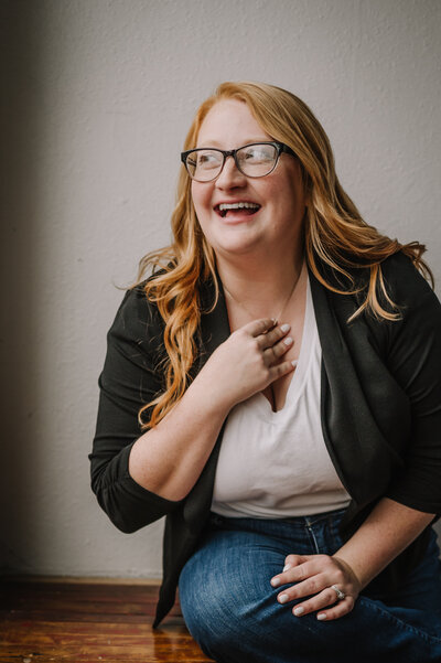 Women with glasses smiling dressed professionally .