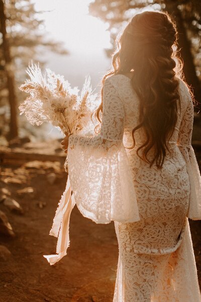 Boho bride with thick textured braid and a lacy dress,