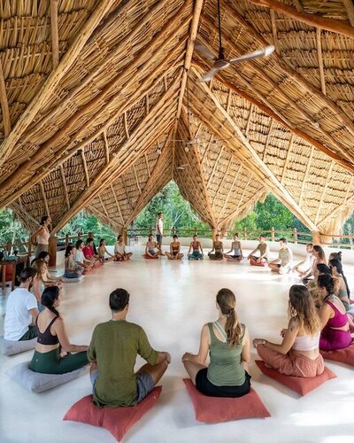 A woman walking barefoot on a jungle path surrounded by tropical greenery at Dora Jungle Retreats in Tulum, embodying peace, grounding, and connection to nature through holistic retreat experiences.