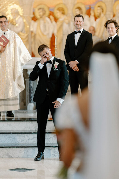 catholic groom crying as his bride walks down the aisle