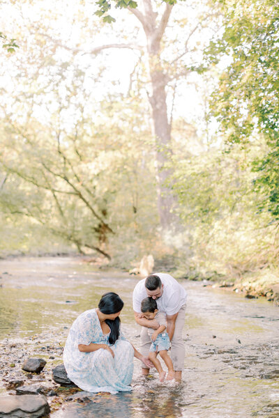 Family explores a creek during portrait session