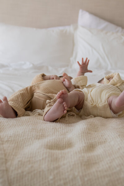 close up of a family of four with big brother smiling while hugging dad and dad is holding baby brother with mom's arm around baby