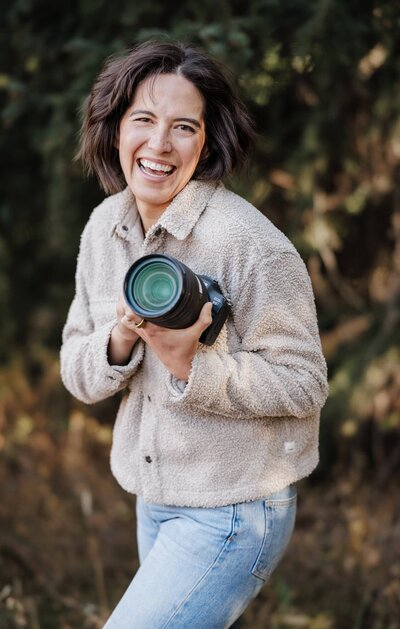 Stephanie Yves Photography smiles with camera while photographing micro wedding.