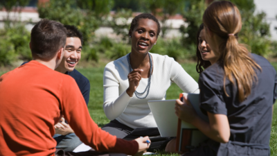a black female college professor talking to students on the lawn