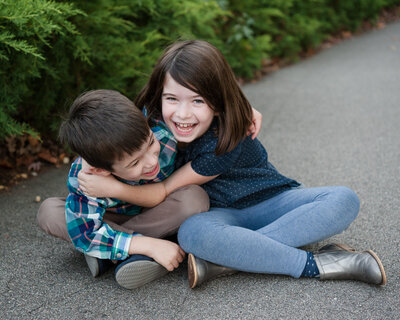 Sibling brother and sister giggling on path - Family Photographer Nashville