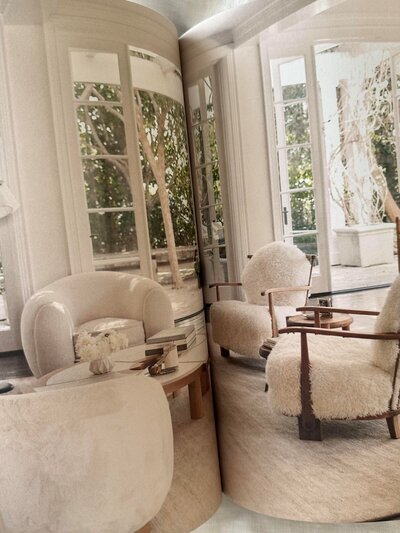 A bright and airy living room from Pacific Natural at Home by Jenni Kayne, featuring French doors opening to the backyard and a relaxed seating area with cream-toned sofa and occasional chairs, perfect for casual, intimate gatherings.