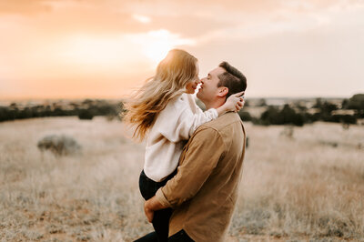 man holding up woman