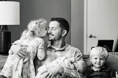 Black and white family photo with three kids and baby