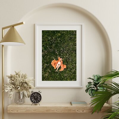 framed photo of pregnant mom laying in field of flowers