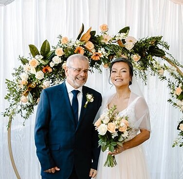 Bride and Groom Elopement setup with floral arch and ocean view