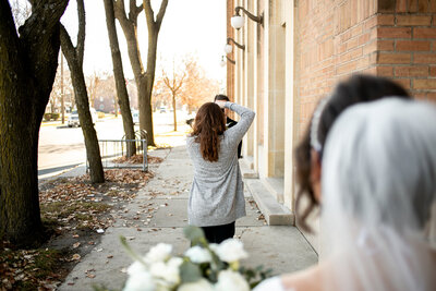 Lori photographing a groom downtown Des Moines while a bride watches