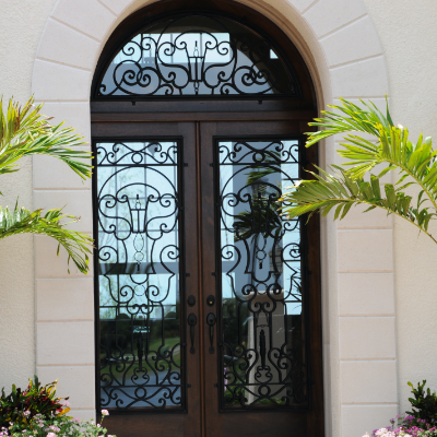 Traditional style entryway with a chocolate brown iron door with triple pane glass windows that allow for extra protection and natural light.