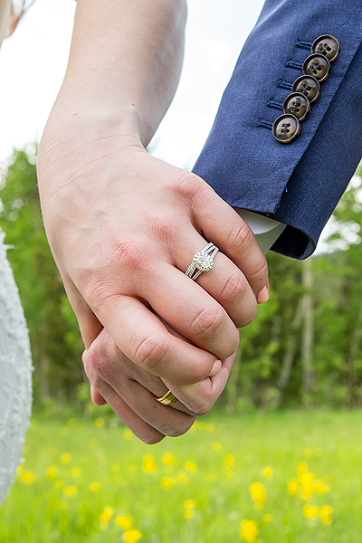 detail shot of wedding rings and holding hands