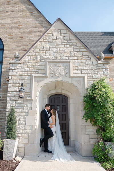 Bride and groom share joyful moment in natural outdoor setting.