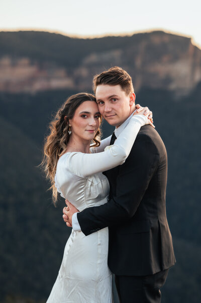 Couple standing on a cliff in the Blue Mountains during golden hour wedding photos