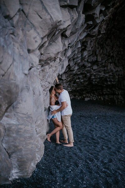 Playful engagement moment inside Iceland’s famous basalt cave, surrounded by dramatic lava rock textures.