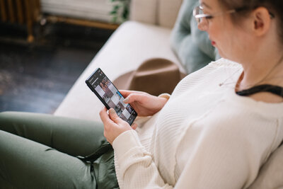 Hand holding a phone with an Instagram feed on the screen