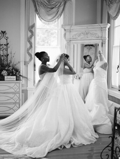 Bride smiling over her shoulder while holding a lush pink and white bouquet in the stone streets of Altos de Chavón — captured by Asia Pimentel Photography.