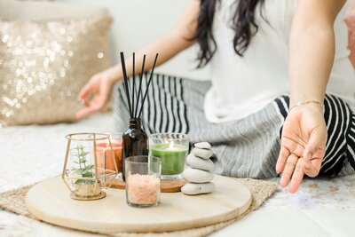 Woman practicing mindfulness with candles, incense, and healing stones—promoting calm, energy alignment, and holistic wellness
