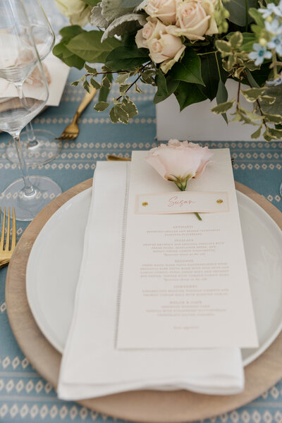 A bright and airy neutral wedding venue photo of the main dining area with brown chairs and white flowers during an alyssa amez design custom wedding