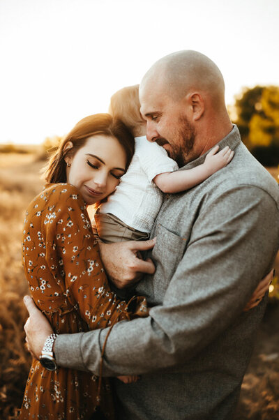 Family holding each other tightly at sunset.