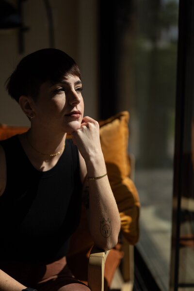 woman sitting in chair resting chin on fist