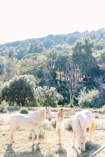bride with two white horses in the hills of spain