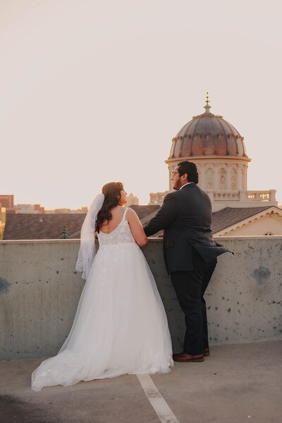 bride and groom embrace on rooftop at Dallas wedding