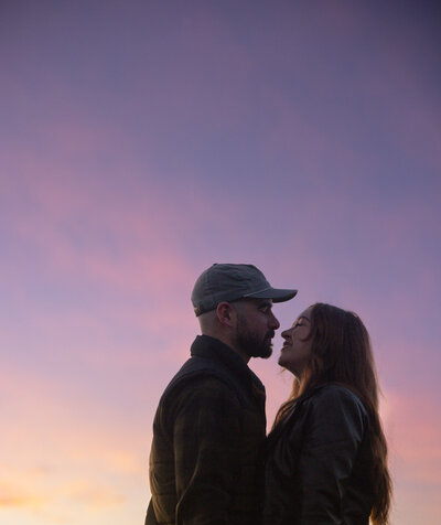 Couple posing with a rainbow  by the shores of Lake Tahoe at sunset
