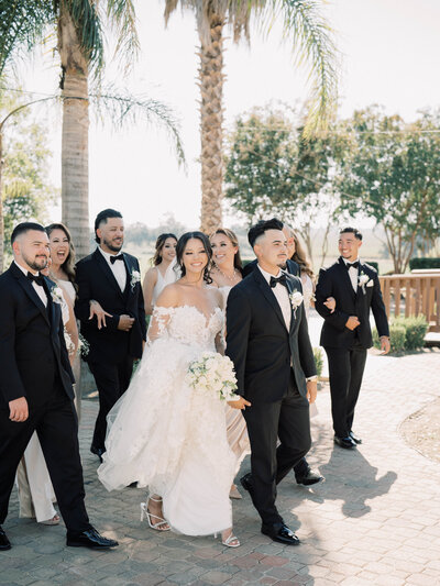 A wedding party and bride and groom at Hanford Ranch Winery walking together as the party starts walking to the reception.