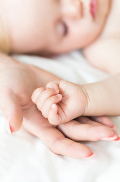 The purest form of love and connection as a new mom tenderly holds her baby's small hand, radiating cuteness and affection at a postnatal retreat