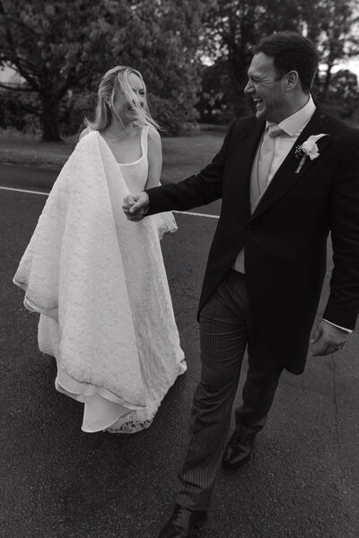 Wedding photographer captures couple taking a stroll hand in hand at their french chateau wedding.